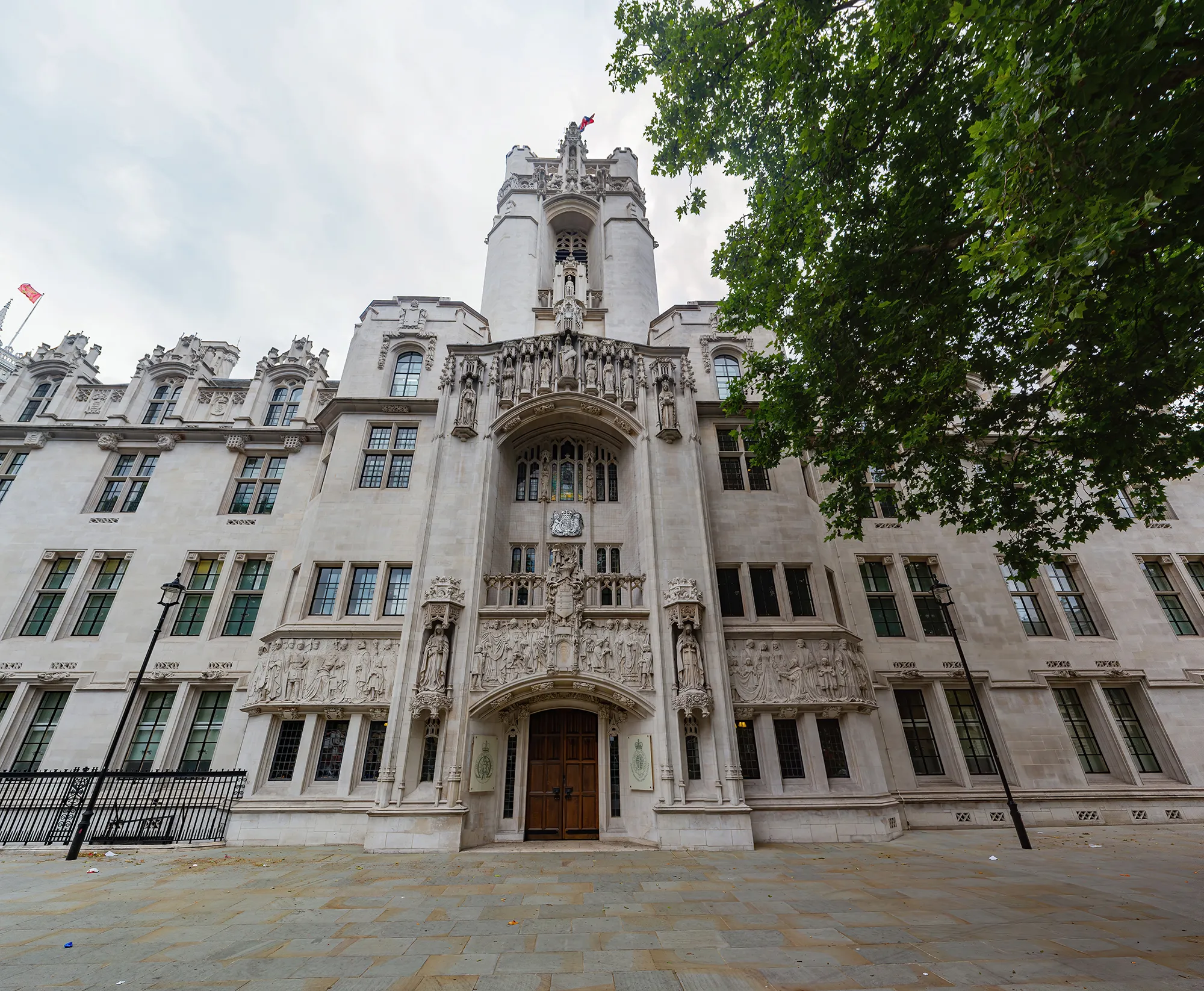 The front of the impressive Supreme Court Building including a tree top right